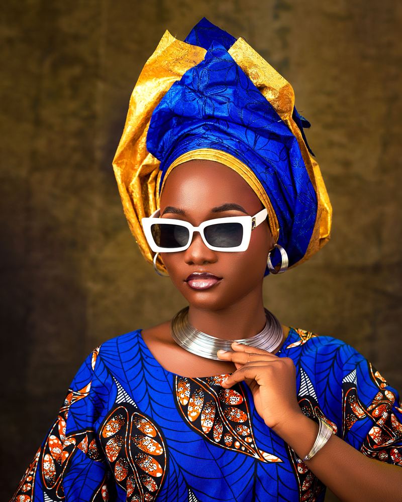 Blue and gold wax headwrap with bold white sunglasses